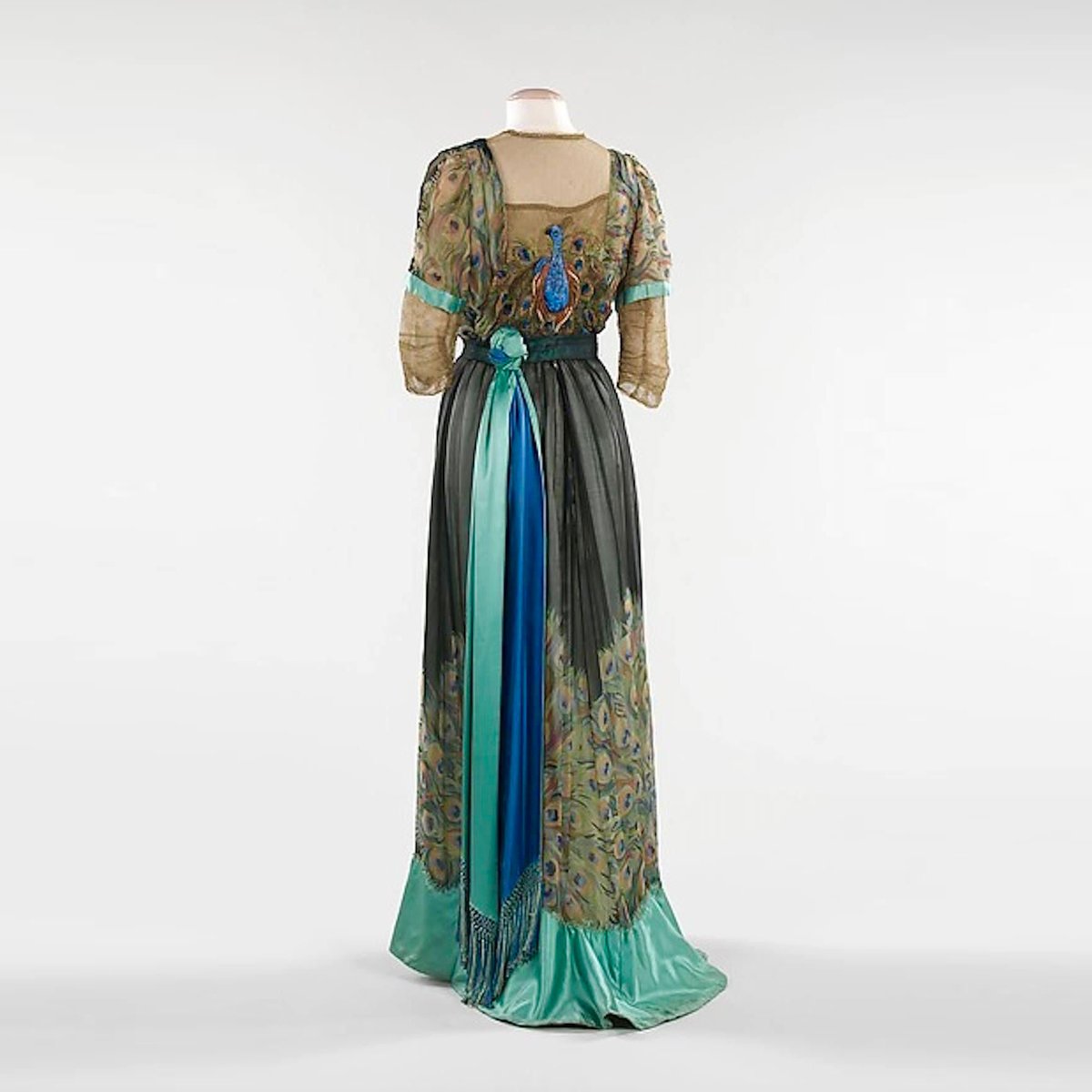 TheVFG's tweet image. 1910 stunning evening gown by the little known Parisian couture house Weeks channels Art Nouveau's fascination with peacock imagery. Both printed and embroidered with metallic thread, peacock motifs give a showy beauty to this gown.
Brooklyn Museum Costume Collection at The Met