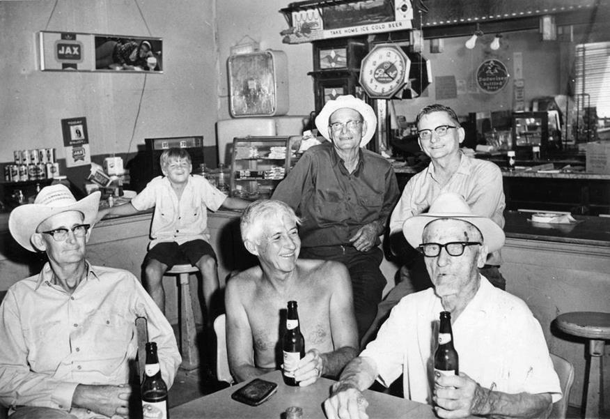 TracesofTexas's tweet image. Otto Lindig drinking beer with some other old German guys from Fredericksburg, 1968. That's famed Luckenbach "imagineer" Hondo Crouch with no shirt on. Looks like Hondo paid: his wallet is on the table. They are drinking Pearl beer. I love the Pearl clock on the wall and the…