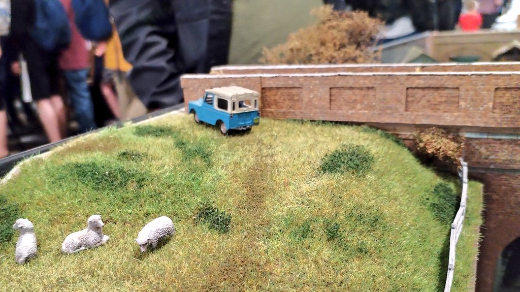 The landrover is in the sheep field.