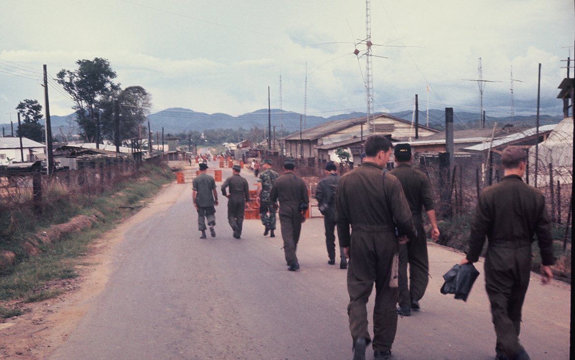 TheReconCast's tweet image. SOG men , Scarface pilots and based on the camo a FAC pilot walk down Highway 14 (a highway that ran from Kontum to pleiku ran right through the center of the compound) towards the Recon Company and TOC . This was the week of OP TAILWIND…
Pc- Barry Pencek