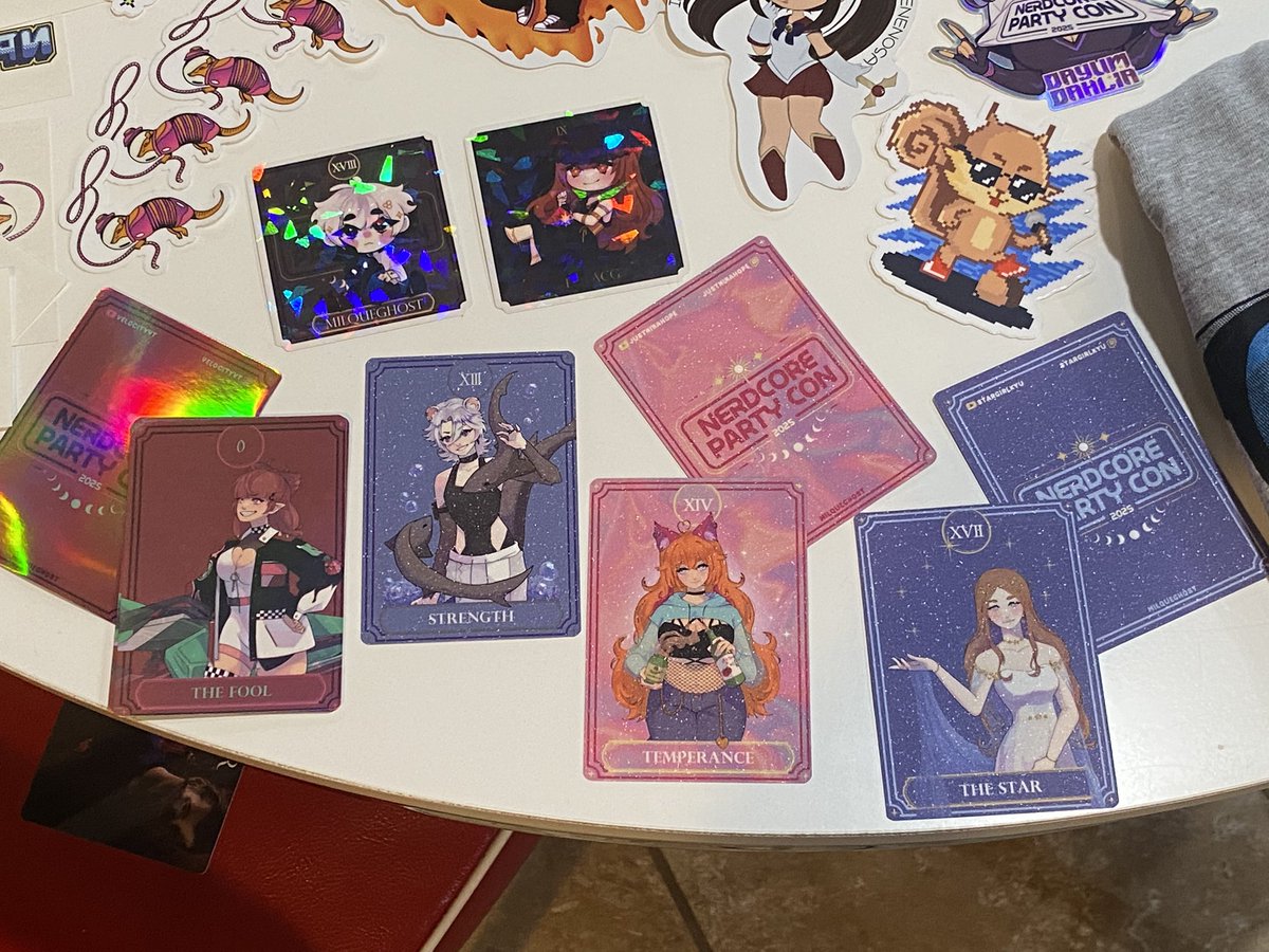 kellyb2076's tweet image. Still getting pics of the haul, but had to share these amazing tarot cards and stickers from @milquegh0st for the vtuber project at #NPC2025! We got The Fool on Friday and on Sunday a bartender slid hubby a full set! 💖 The extra holo and texture are so gorgeous and next level!!