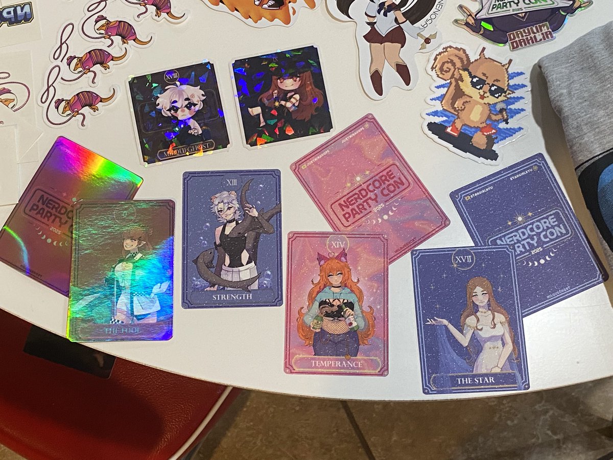 kellyb2076's tweet image. Still getting pics of the haul, but had to share these amazing tarot cards and stickers from @milquegh0st for the vtuber project at #NPC2025! We got The Fool on Friday and on Sunday a bartender slid hubby a full set! 💖 The extra holo and texture are so gorgeous and next level!!