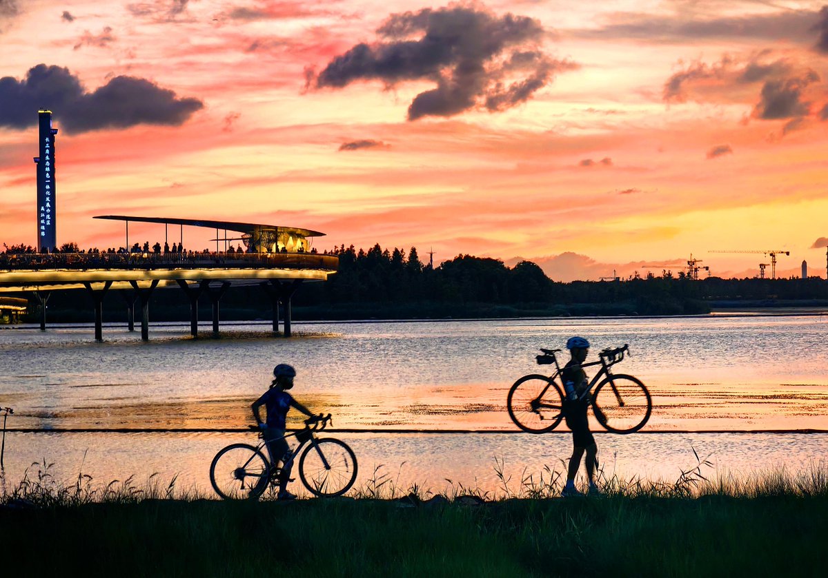 SixthTone's tweet image. Visitors take in a fiery sunset over Yuandang Lake in Shanghai, July 19, 2025. VCG