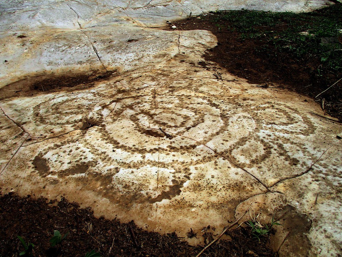 beforethewest's tweet image. Hidden in the limestone plains of Bidzar, northern Cameroon 🇨🇲, lies a remarkable and little-known collection of ancient petroglyphs. The carvings, like the spiral design pictured here, are pecked into the rock with surprising precision. Their true meaning remains uncertain, but…