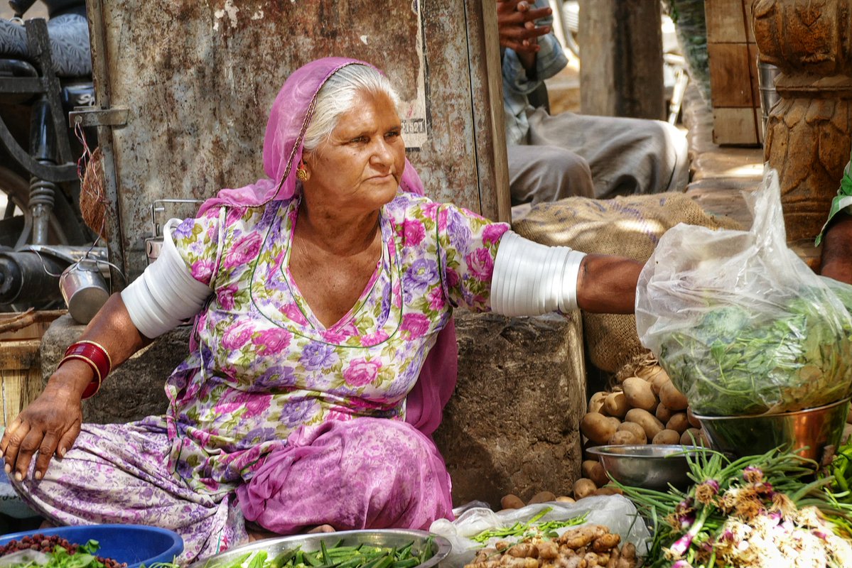 CompuCowBoy's tweet image. Ordinary color moments in India: Rajasthan, 2018. A woman in Jaisalmer sells greens and fresh produce. This scene occurs not only in markets but also in small villages and residential neighborhoods on street corners. #India #travelphotography #streetphotography