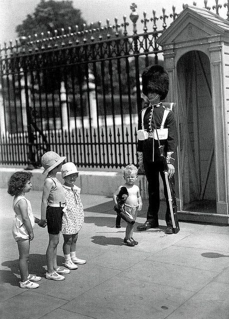 OldEngland1066's tweet image. A charming photograph, children gazing at a Royal Guard, Buckingham Palace, London, 1933.