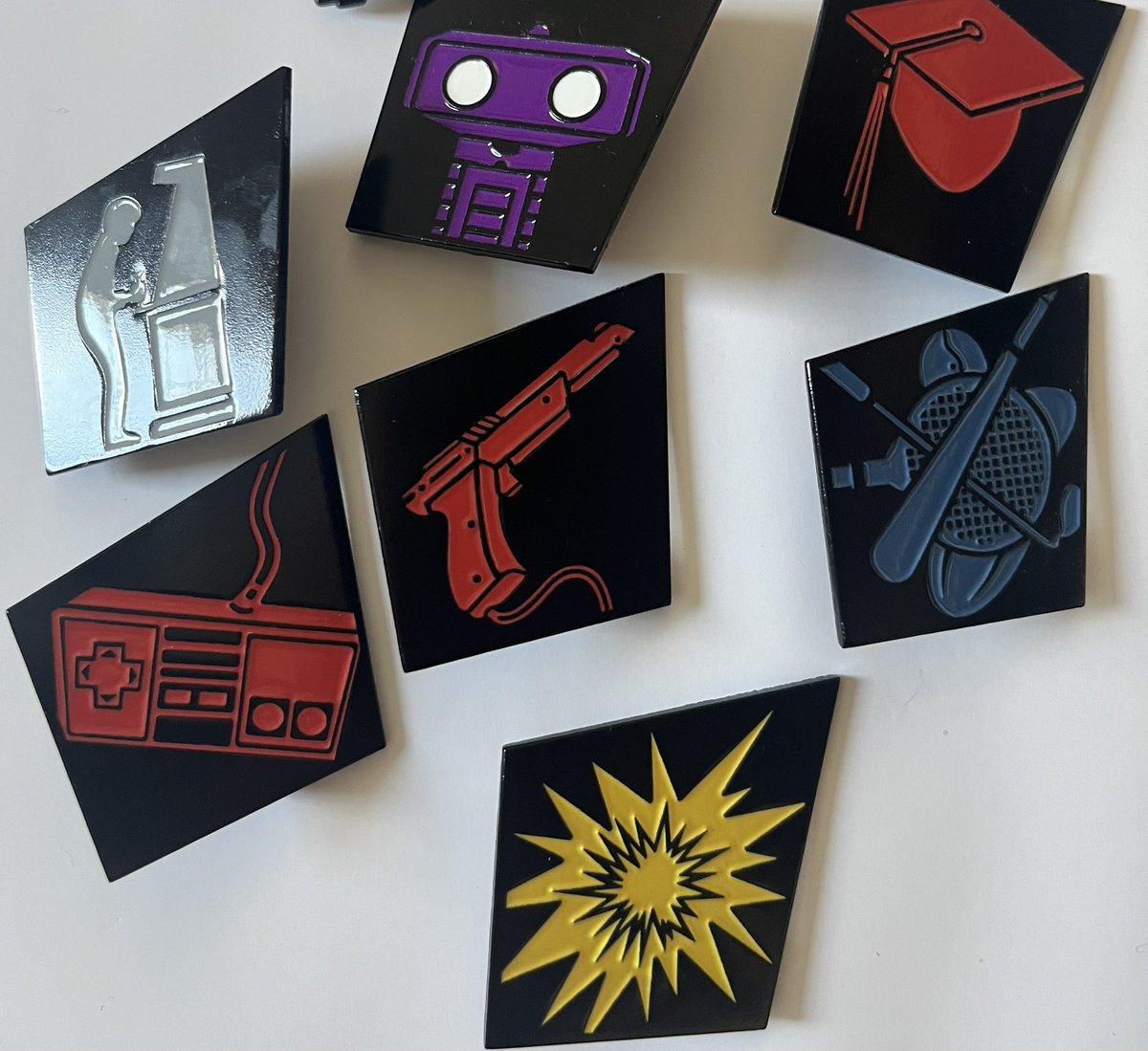 Liretro's tweet image. Get a closer look at the 7-piece pin set as part of the NES AT 40 Exclusive Merch add-on! Each is modeled after the memorable icons utilized for the original classic black series of titles for the NES. Get this set plus the GIANT SIZE NES x LIRetro cartridge replica, exclusive…
