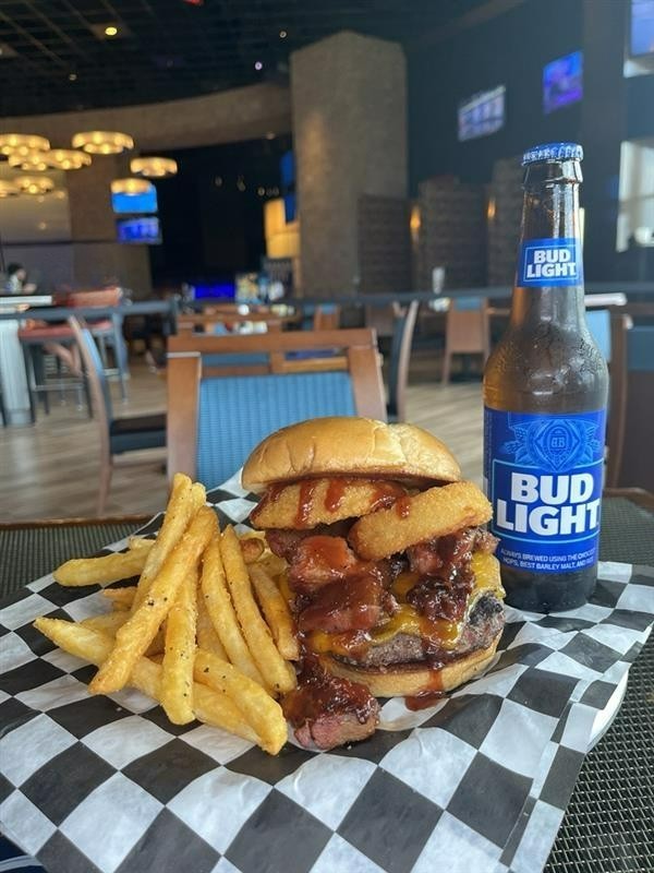 🍔 August Burger of the Month! 🍔
Open wide for the Brisket Burger! A tower of beef brisket and onion rings on a patty with cheddar cheese and BBQ sauce between brioche buns. 🤤 Served with fries or slaw for $17, only at Turn 2.