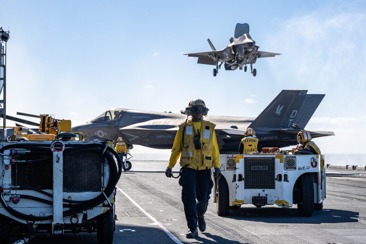 USNavy's tweet image. #USNavyPhotosoftheDay
1️⃣ Aviation Boatswain’s Mate (Handling) 3rd Class Ashley Oscar, center, from Atlanta, assigned to the forward-deployed amphibious assault ship USS America (LHA 6) walks across the flight deck while conducting flight operations during Exercise Talisman…
