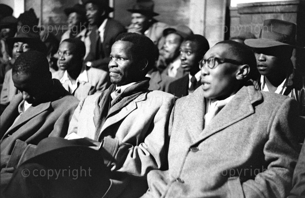 HistorySAZAR's tweet image. Dr Rex Tabane, Oliver Tambo and Dan Chocho (visible behind Tabane) watching a game of boxing, c 1955. On Tambo's right is Sy Mohapi, a reporter from Drum Magazine who appears to be nodding off