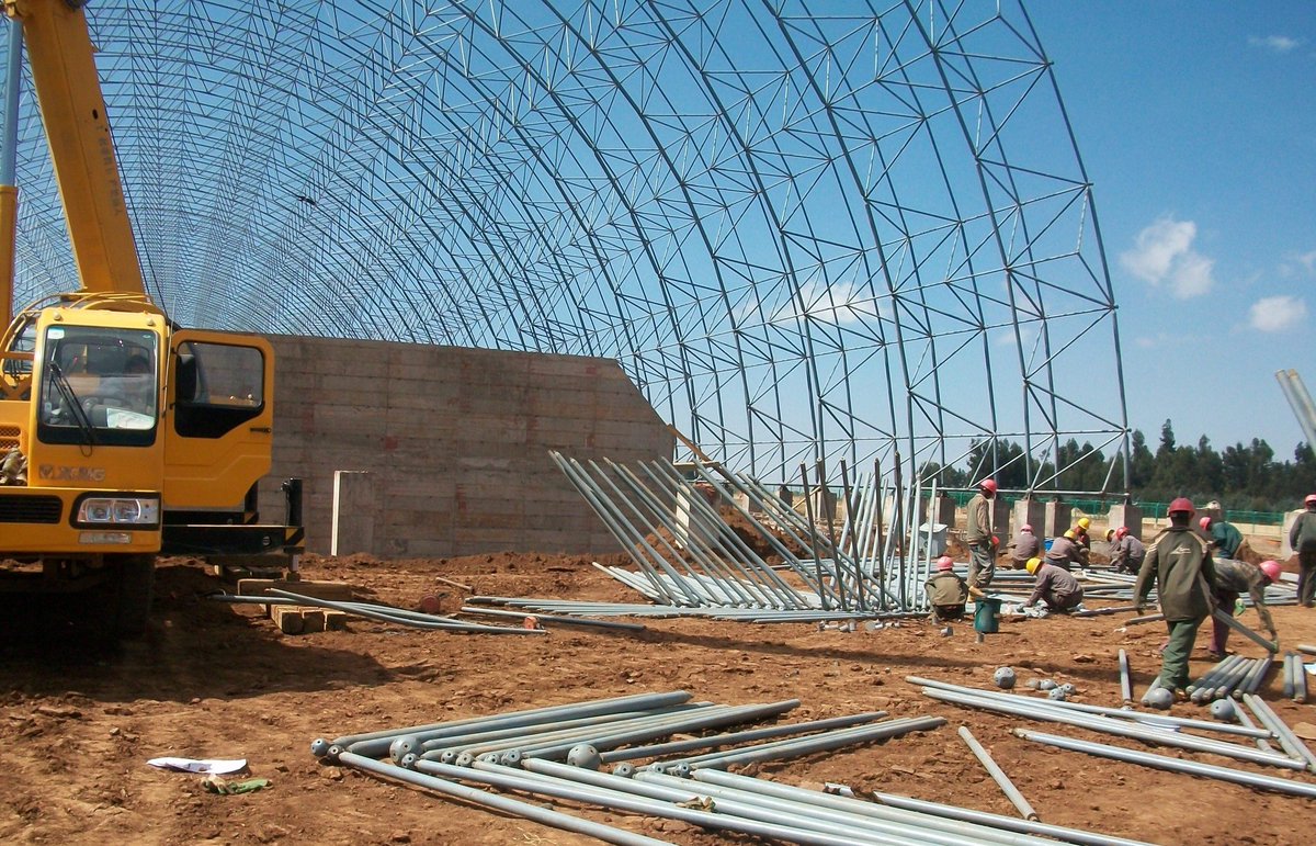 هندسة دقيقة لساحة مواد خام عملاقة
هل تبحث عن حلول مبتكرة لتغطية مساحات شاسعة لتخزين المواد الخام؟ في أحد المشاريع  الأخيرة لساحة تخزين المواد الخام، قمنا بتصميم وتصنيع هيكل شبكي (Lattice Shell) فريد.
يعتمد هذا الهيكل على نظام أسطواني مزدوج الطبقات، بوحدات هرمية رباعية قائمة،