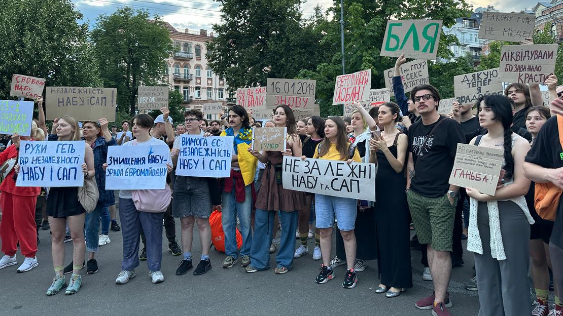 dw_ukrainian's tweet image. ❗ На тлі війни Верховна Рада і президент за день обмежили незалежність НАБУ і САП. Це викликало спонтанні протести в низці українських міст. У Києві мітингарі казали про "відкат у часи Януковича". Серед мітингувальників - публічні особи, військові, ветерани, активісти. Акція…