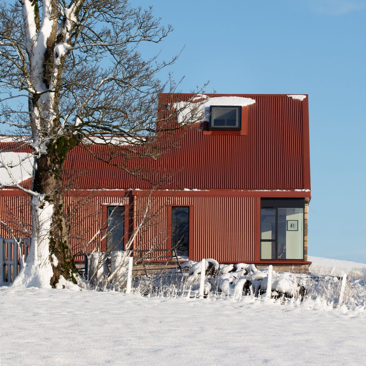 dezeen's tweet image. Five unassuming houses crowned with bold red metal roofs: dezeen.com/2025/07/20/red…