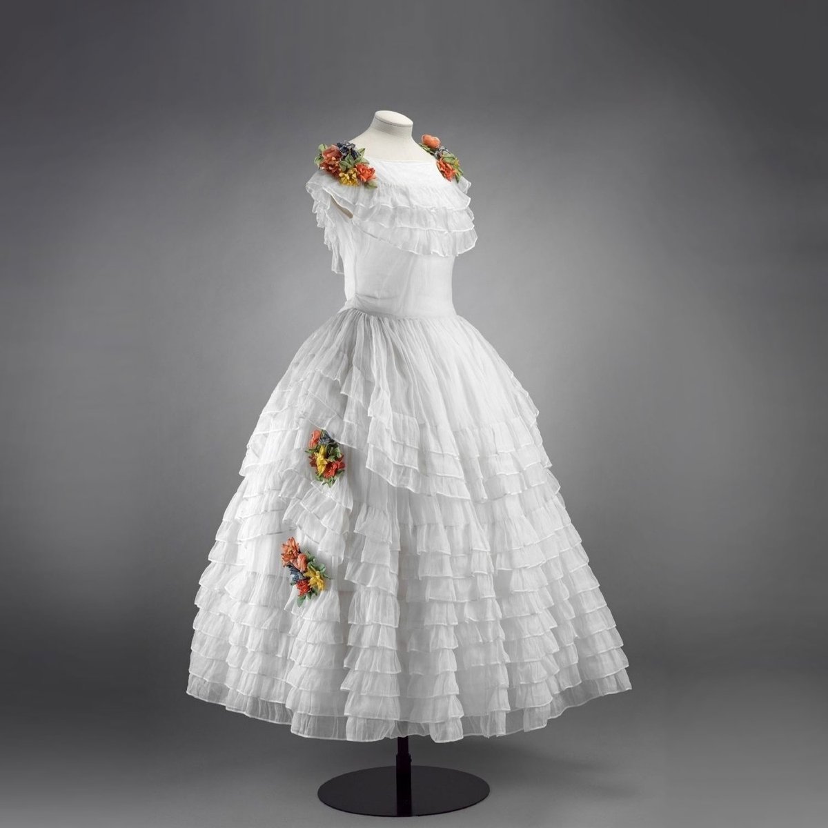 TheVFG's tweet image. Jeanne Lanvin's Robe de Style. Delicate white organza layered with ruffles and adorned with silk flowers. Worn on and off the stage by Spanish actress Cátalina Bárcena. Victoria & Albert Museum