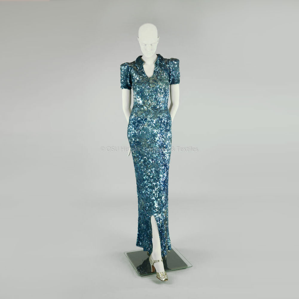TheVFG's tweet image. This blue sequin 1930s evening gown is attributed to Chanel. The short sleeves, structured shoulders, small collar, and triangular hip accents reflect Chanel’s eveningwear during the late interwar years. Historic Costume & Textiles Collection of Ohio State University