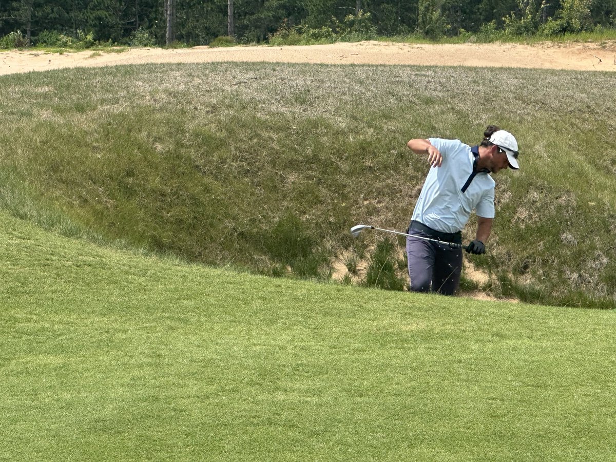 Ryonen Faris of Fond du Lac turns away from wind-blown sand after hitting his second shot from a tiny fairway pot bunker on the 6th hole at The Lido in the third round of the ⁦<a href="/WSGAGolf/">WSGA Golf</a>⁩ State Amateur.