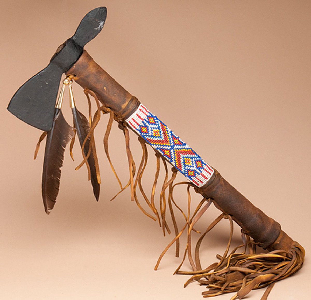 beforethewest's tweet image. Navajo-Style Tomahawk – Southwestern Plains (late 19th century)
This intricately beaded and feathered tomahawk served not just as a weapon but also as a ceremonial and diplomatic symbol among various Plains tribes. Decorated with bright beads and eagle feathers, these hatchets…