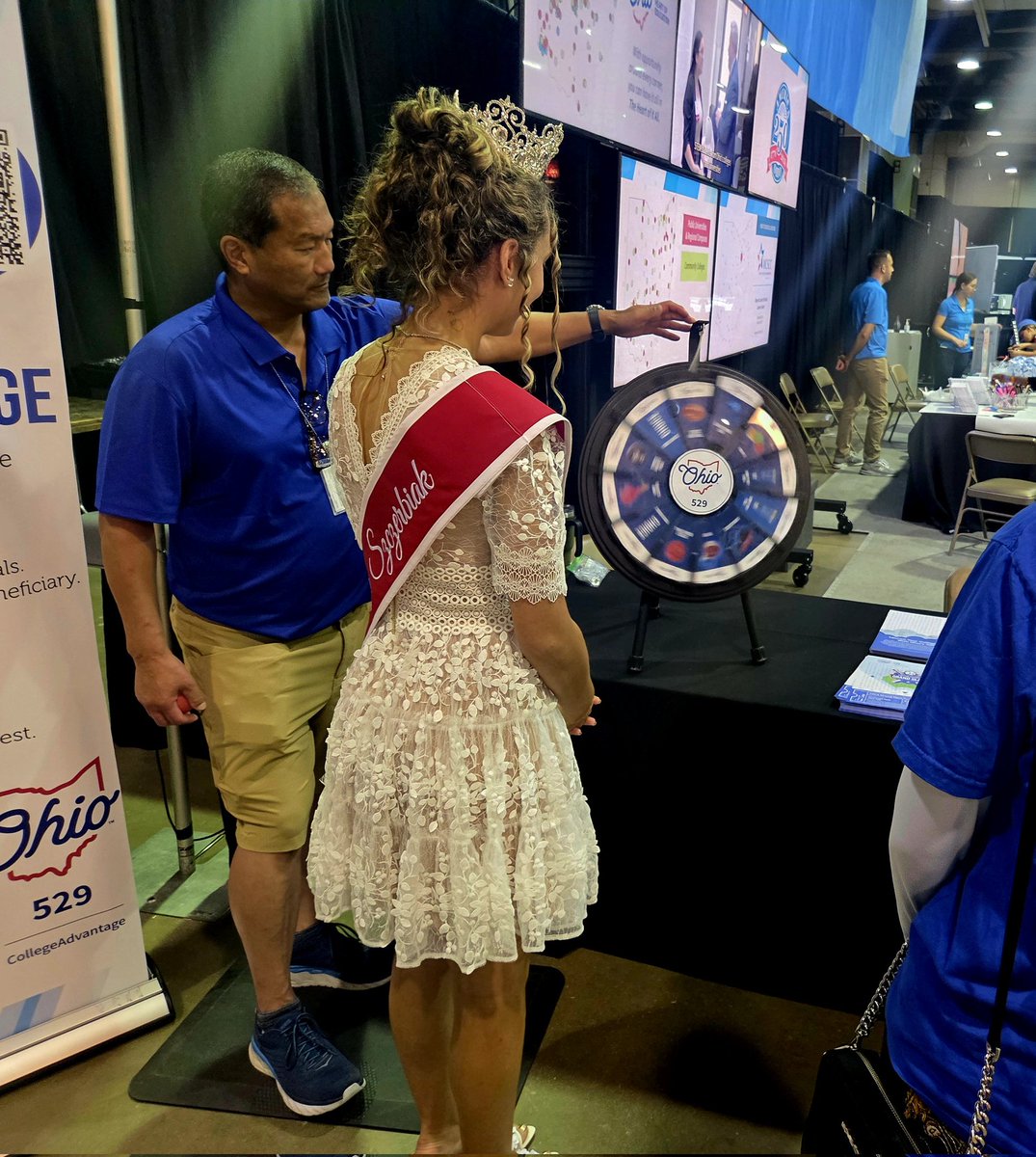OhioHigherEd's tweet image. The 2025 #Ohio Fairs' Queen, Amberly Szczerbiak, spins the @Ohio529Plan prize wheel at the ODHE @OhioStateFair booth and selects her prize with help from her dad, former @miamiuniversity and @NBA basketball star Wally Szczerbiak.
