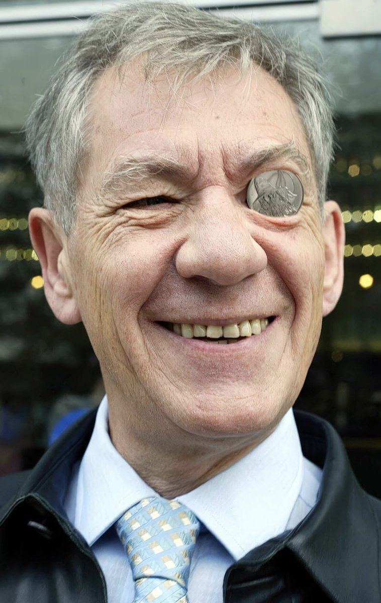 Sir Ian McKellen holding a New Zealand coin with Gandalf on it - 2003