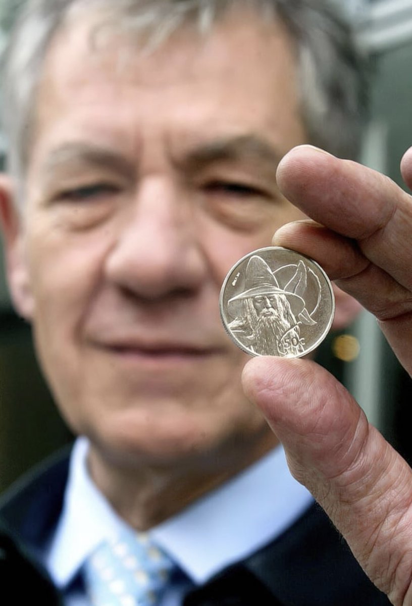 TolkienWorldG's tweet photo. Sir Ian McKellen holding a New Zealand coin with Gandalf on it - 2003 https://t.co/mFwjC7mZqc