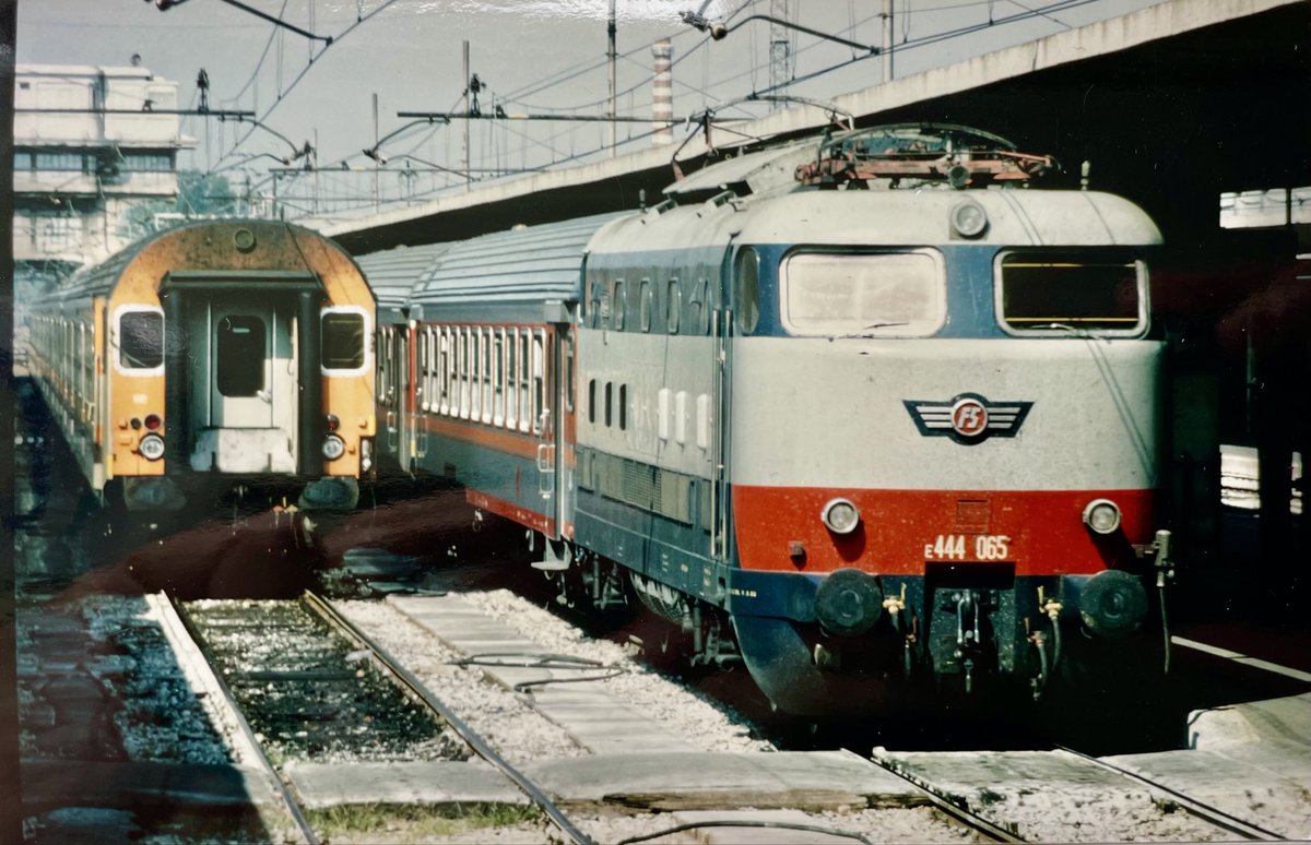 AndreasWiede's tweet photo. A picture, taken from the open window of a train, stopping at #Bologna 🇮🇹 in June 1985. We come across two #FS medium-distance services: on the left, a (not exactly streamlined) #MDVC cab car and on the right a Class #E444 “Tartaruga” (🐢) electric, hauling a rake of #MDVE cars. https://t.co/eyyXcq6rau