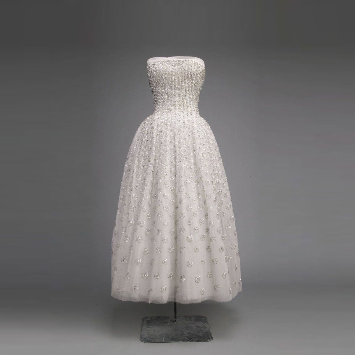 TheVFG's tweet image. “Flower Women” in Full Bloom: Dior, 1954
Dior created flower women...with tiny waists like stems and skirts belling out like petals.” This 1954 evening dress embodies that vision, with a sculpted strapless bodice and skirt blooming in silk tulle. Chicago History Museum