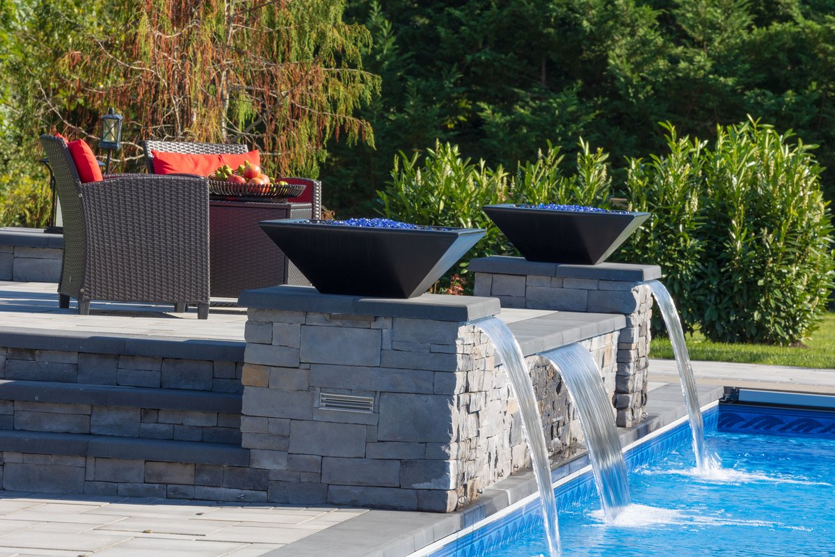 Every detail in this outdoor space is designed for elevated living—from the tranquil waterfall features to the cozy fire pit that makes the whole space pop. Whether you're lounging, dining, or enjoying a midnight swim, this patio is made for memories. #OutdoorLiving