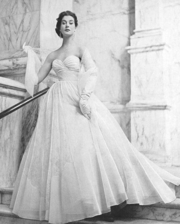 We just adore this evening gown of fine white lace and nylon from Debenham &amp; Freebody, which was photographed by Peter Clark and featured by The Tatler, 1 June 1955. Consummately elegant, it's perfect for a summer ball bit.ly/3J3ZyQk #FridayFashion