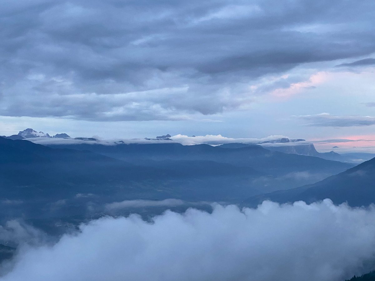 Hochtouren's tweet image. Heute gegen 21 Uhr schauen einige Dolomitenspitzen aus dem Nebel über dem Eisacktal heraus und ein leichter Schimmer Abendrot bereichert die Szenerie (rechts der Schlern) #Südtirol