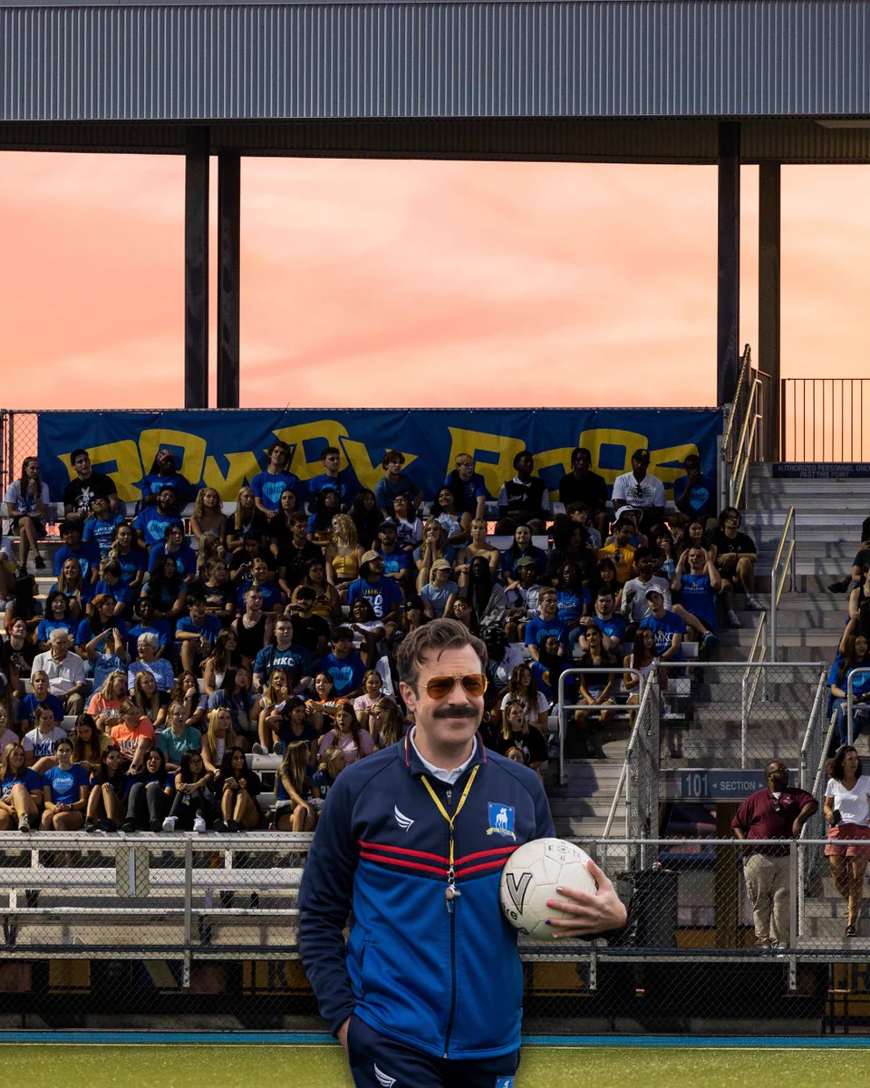 Ted Lasso, a tv character played by Jason Sudeikis, is photoshopped into a photo of a full Durwood Stadium during a soccer game. Ted wears a soccer coach uniform and whistle. 