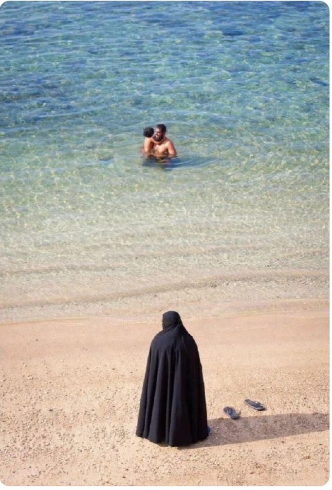 Il maschio - schiavista- islamico si gode il sole e l' acqua del mare. La donna deve soffrire perché è un essere inferiore..RIFLETTETE SINISTRATE