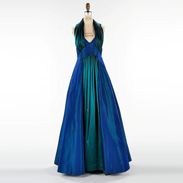 TheVFG's tweet image. Elizabeth Hawes designed this 1936–37 extraordinary evening ensemble named “The Styx.” The dress and matching bolero combine sculptural construction with dramatic blue-green iridescent silk—echoing the movement and mystery of the river from which it takes its name. The MET