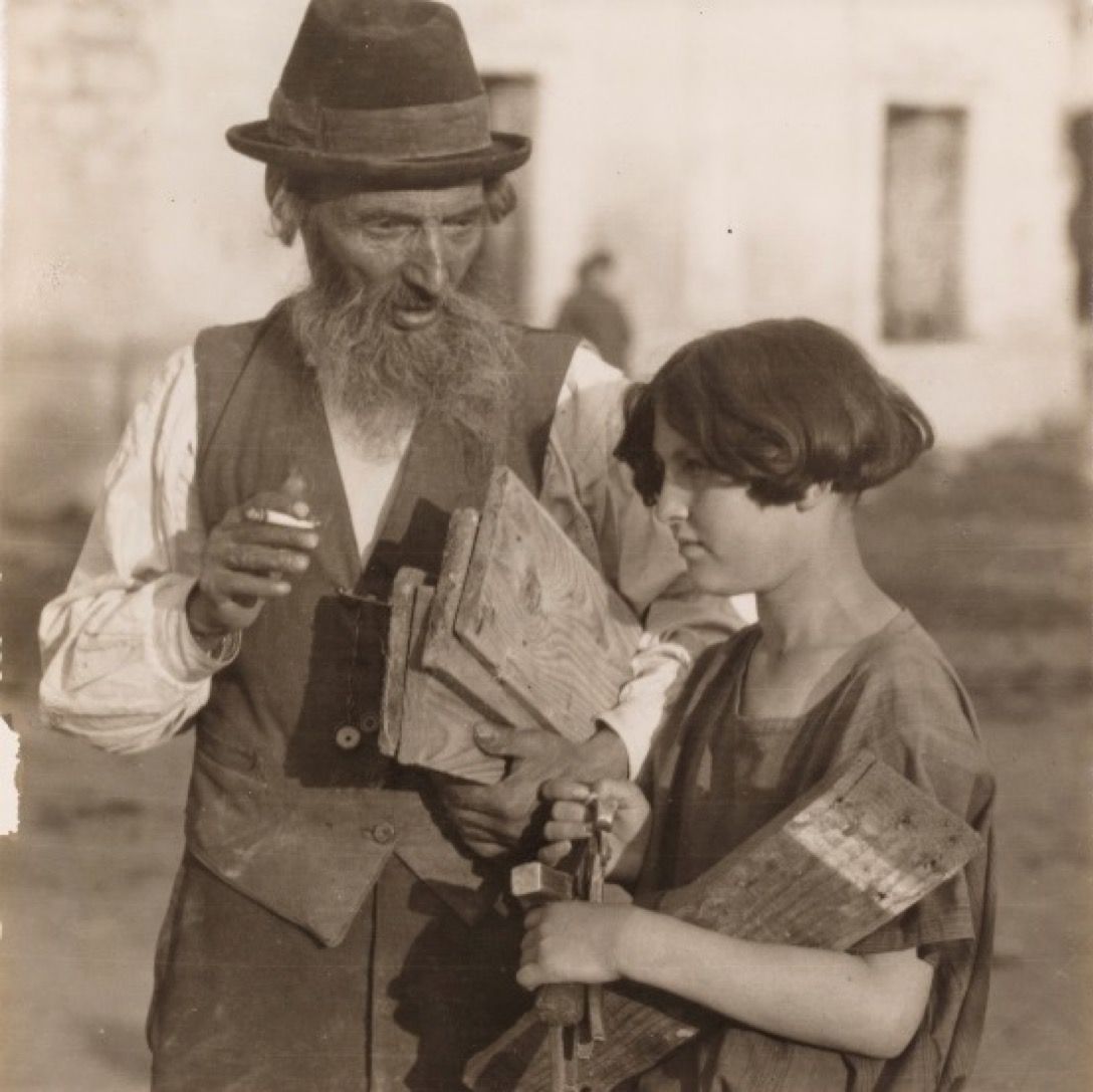 100YearsAgoNews's tweet image. July 26, 1925: A Jewish carpenter with his daughter, who helps him carry some of his equipment in Czortkow, Poland (now Chortkiv, Ukraine).
