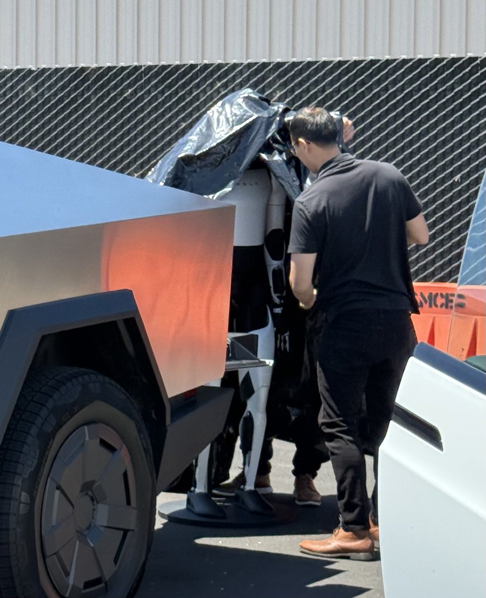 Dragonboy155's tweet image. 👀 at the X Takeover!!
Optimus just got unloaded and quickly covered!
Tesla Bot $TSLA