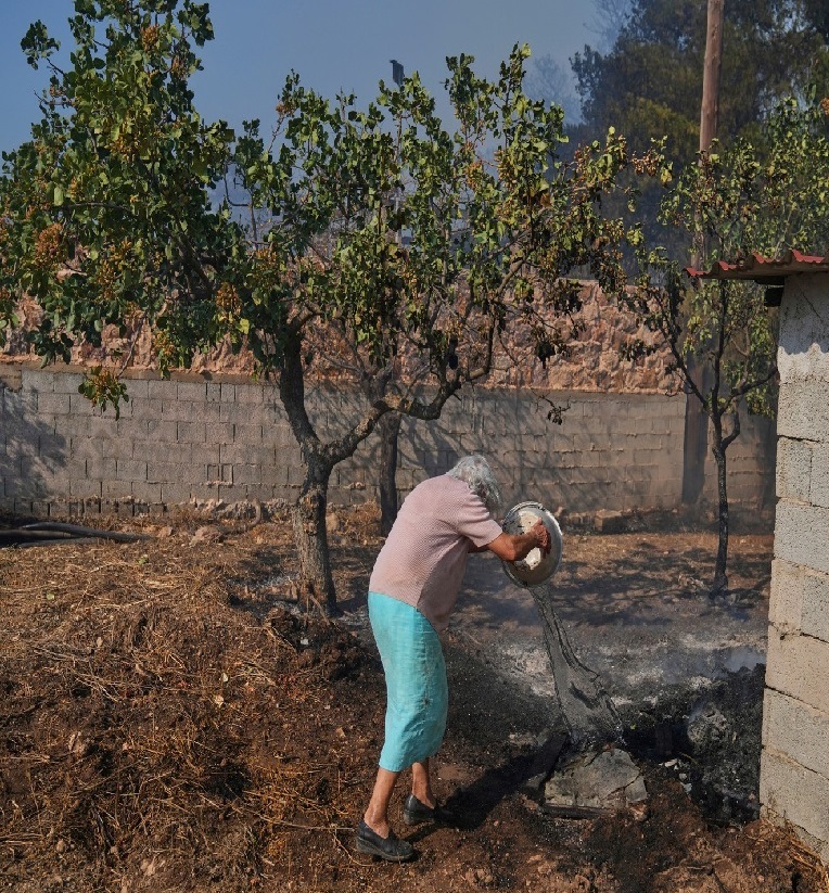 Η κυρία Σταματίνα, 86 ετών, προσπαθεί να σώσει ό,τι σώζεται.
Κερατέα, 08.08.2025
📷 AP / Thanasis Stavrakis