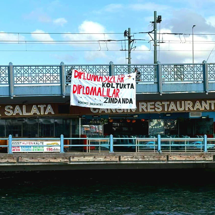 İstanbul Öğrenci İnisiyatifi, ‘sahte diploma’ skandalına dikkat çekmek için Galata Köprüsü’ne pankart astı: 

“Diplomasızlar Koltukta, Diplomalılar Zindanda!”