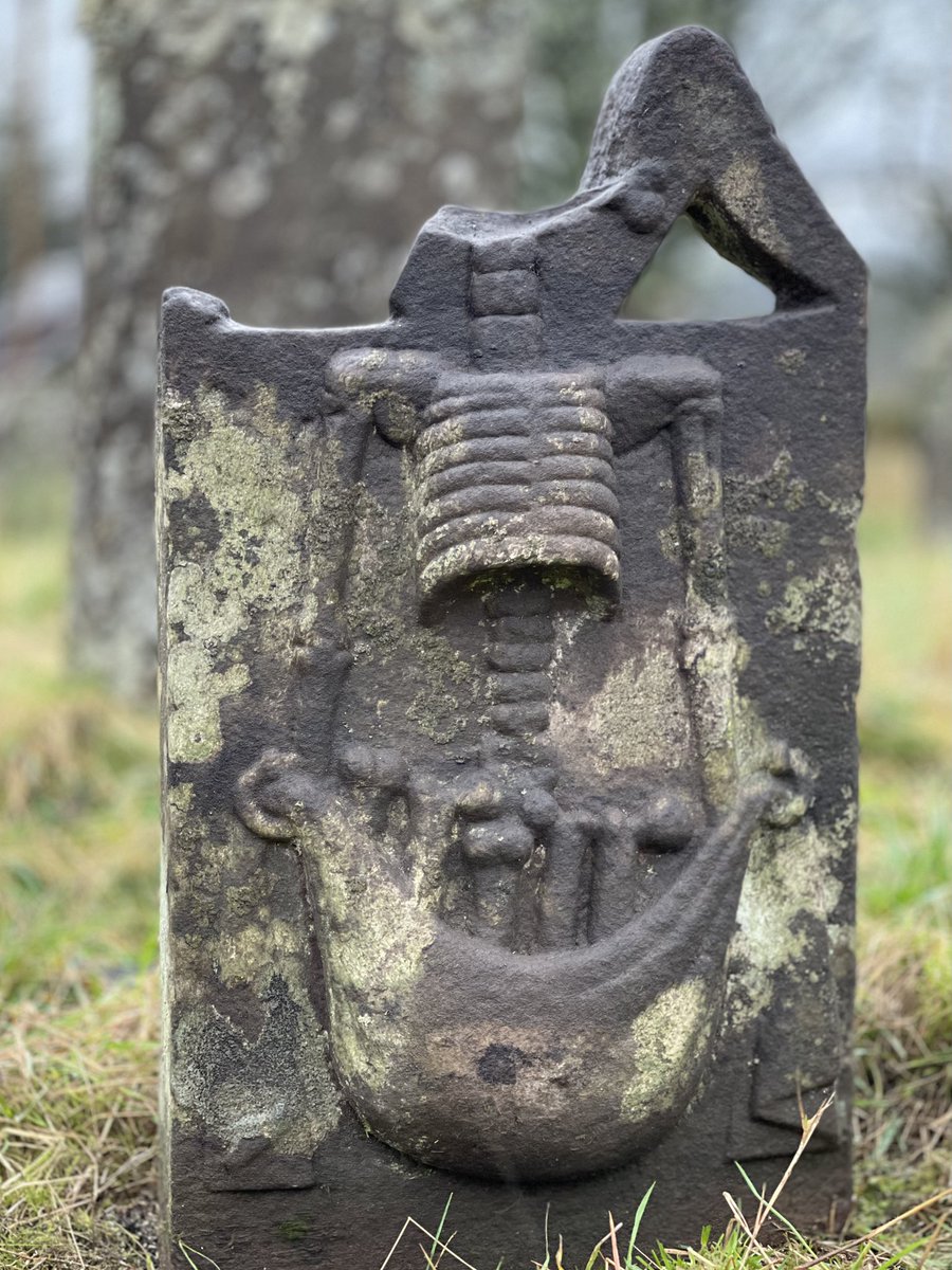 Just imagine what this small gravestone would have looked like when complete. A skeleton holding a bag of bones. Did it hold a bone in its mouth ? 
Now try &amp; imagine why this family chose this design to mark their grave. What are they saying to us here &amp; is it about them or us ?