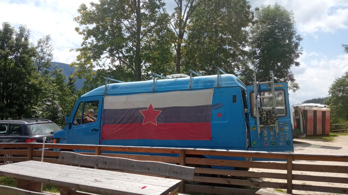 Tako izgleda "tabor koroških mladih domoljubov". Sonja Lokar je stara 77 let, Janez Stariha pa okoli 50. Na drugi fotografiji je viden plakat, nalepljen na hišo, kjer piše "ANTIFA CAMP". 🎯

V glavnem - šlo je za zborovanje Antife oz. komunistov. Zastav Republike Slovenije na