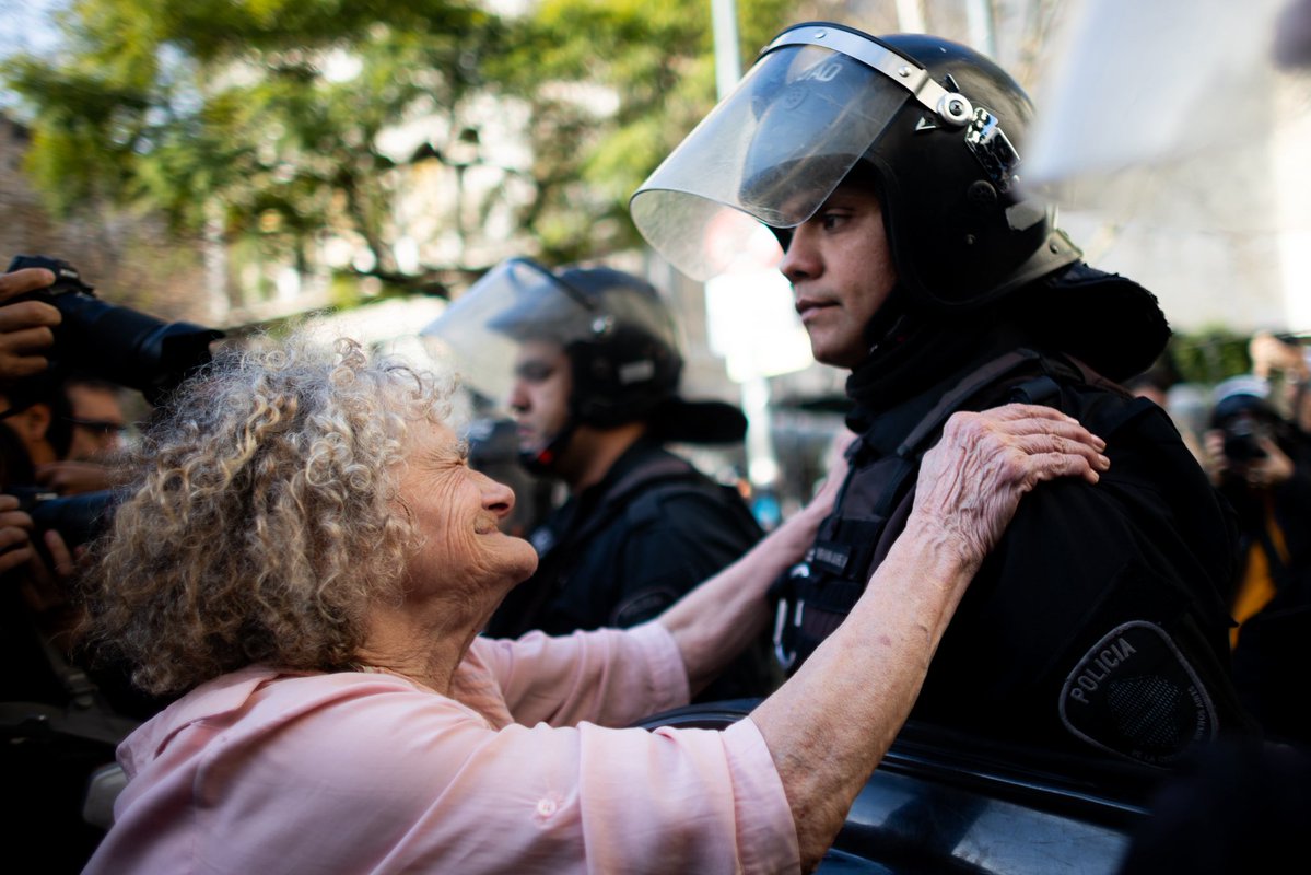 Una jubilada intenta abrazar a un policía de la Ciudad de Buenos Aires durante la marcha de todos los miércoles frente al Congreso.