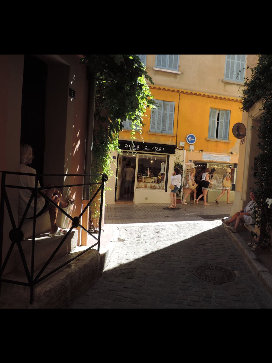Two lady’s sitting talking to each other , over the passage without cellphones in sight. Location San Tropez. France