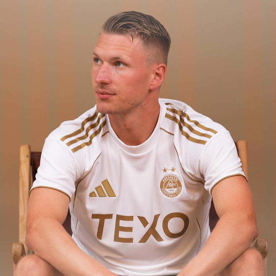 TheShirtUnion's tweet photo. ⬜️| @AberdeenFC Euro Shirt 25/26

Inspired by previous European glories, particularly the historic 1983 Cup Winners’ Cup triumph.

Featuring a crisp white base with gold detailing, echoing the style of Real Madrid who the Dons famously defeated on that historic evening in 1983. https://t.co/e45Bbab0JT