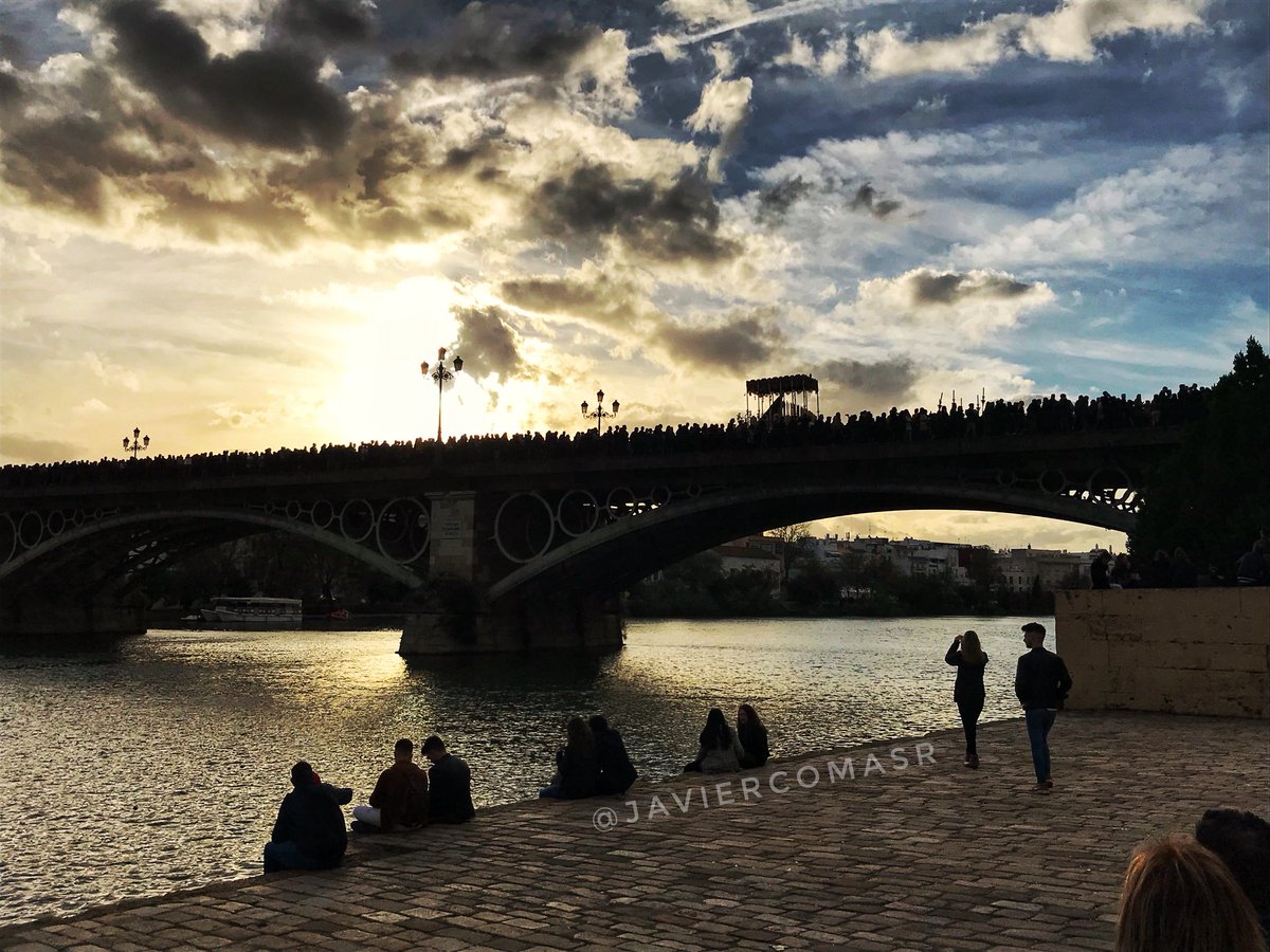 Impresionante atardecer al paso de la Virgen de la O por el Puente de Triana en la tarde del Viernes Santo.

📸 <a href="/JavierComasR/">Javier Comas</a>