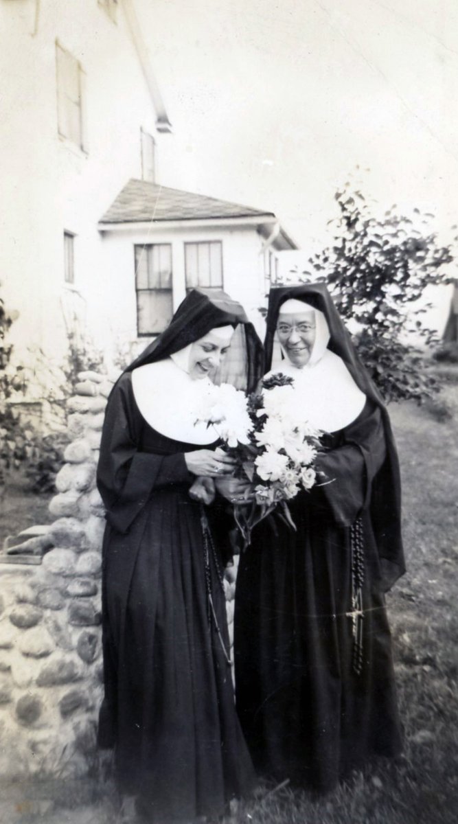 #ThrowbackThursday to Sisters Marie Alice Schauseil and Herman Joseph Murphy enjoying summer blooms at St. Mary's Convent, Elmira, ca. 1940. Sister Herman Joseph devoted 57 years of service to St. Mary's Parish, from 1906 until 1963, as a teacher and school principal. #tbt