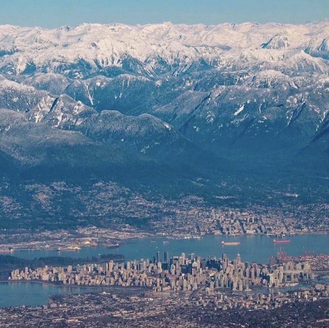 Aerial view of Vancouver’s skyscrapers in front of the majestic mountains ❤️🇨🇦