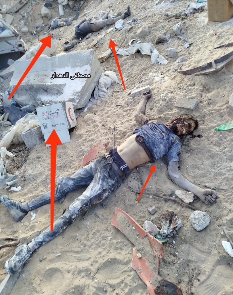 Among the bodies of victims of Israeli-American starvation and barbarism stands a sign reading: "Human First!" 
This is their humanity!
#GazaGenocide #GazaGenocide