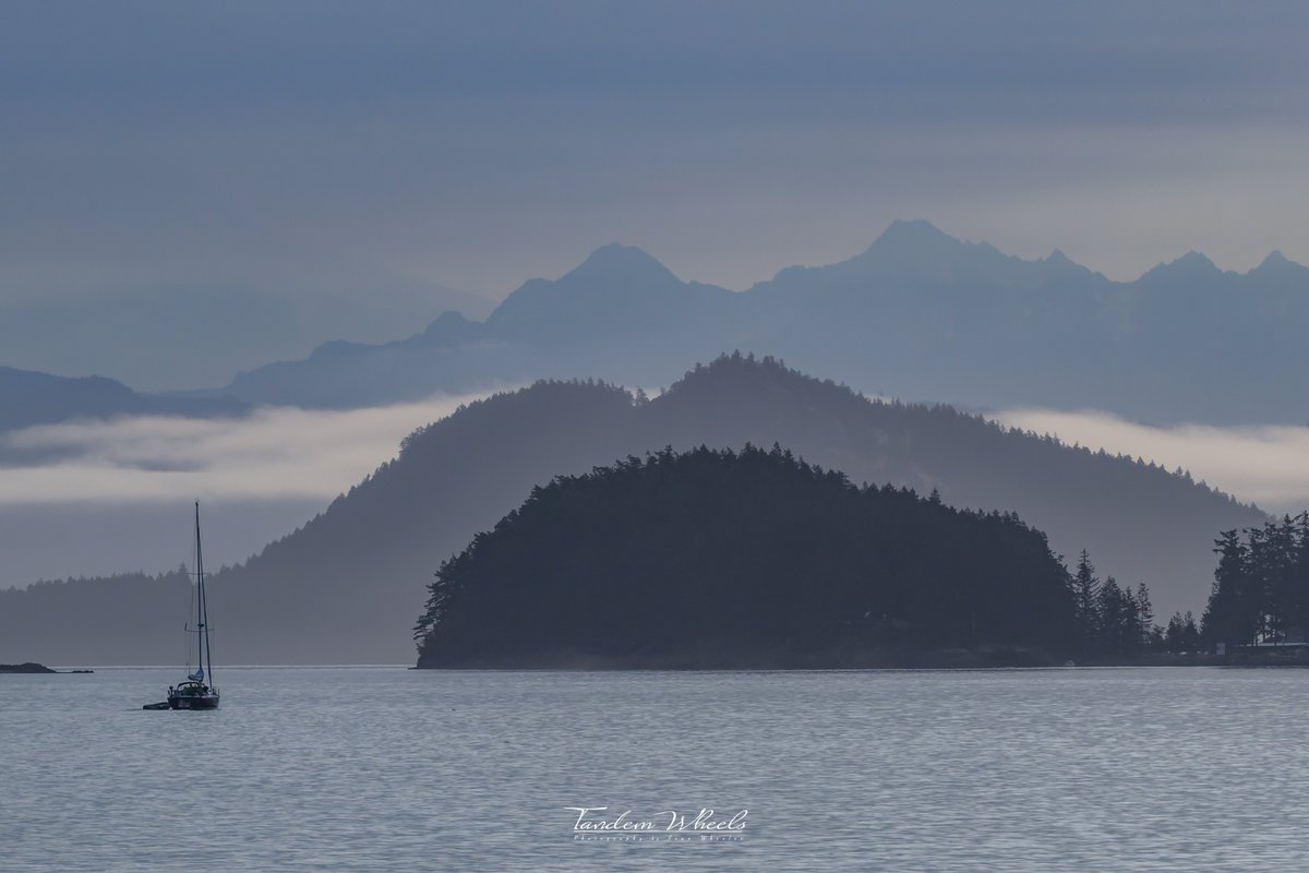 Layers into the mountains - ⛵️ 
A view to the east with Blakely and Cypress Islands. In the distance, the blueish haze over the Twin Sisters and the single sailboat.   #wawx #pnw #nature