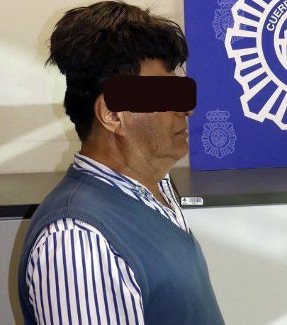Mugshot of a Colombian drug smuggler caught at Barcelona Airport with half a kilo of cocaine glued to his head under a fake wig.