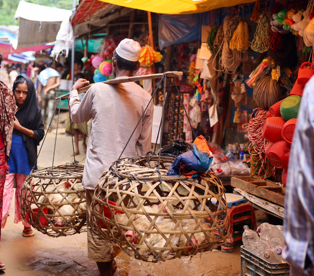 🌟A Moment in Time 📷

Why we love this picture?

The #Rohingya refugee camps have their own distinct style of organised chaos, with so many people, objects &amp; even small animals in such a tight space! The challenge to navigate life here was captured in this colourful snapshot.