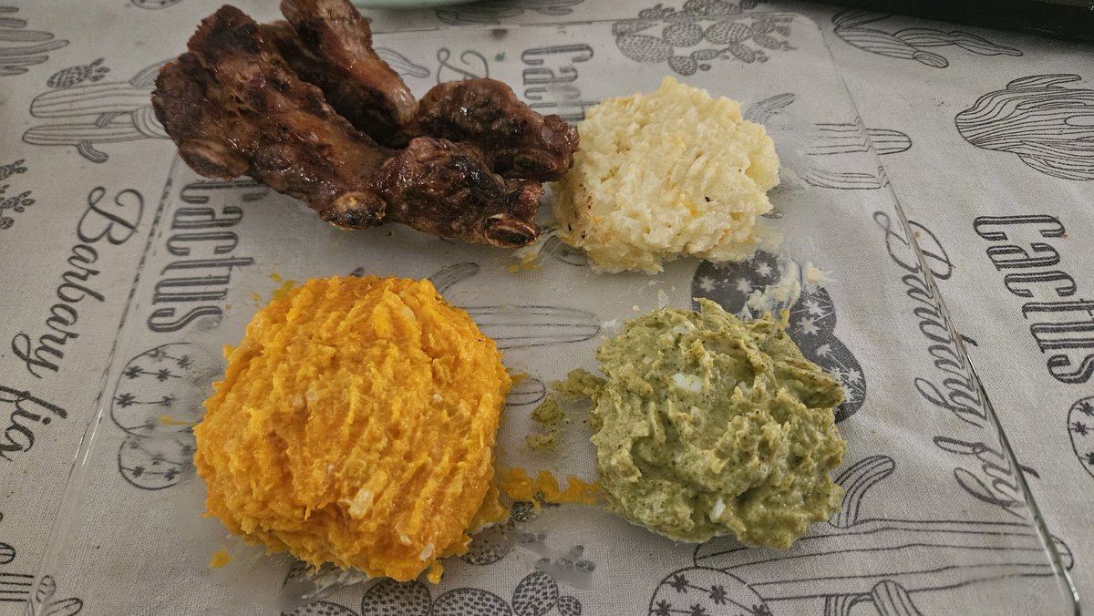 Costillas asadas acompañadas de puré de calabaza, papa y brócoli.