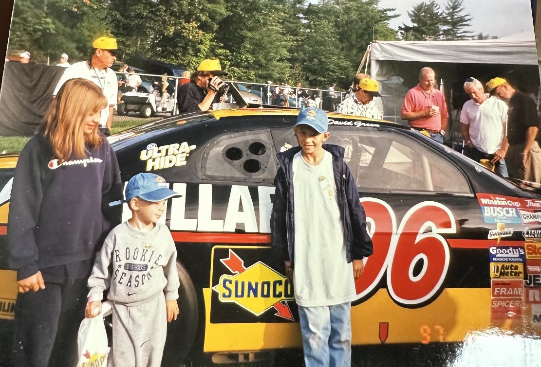 This is me showing David Green this picture of me in front of his car at NHMS in 1997 when I was 9 (picture on the right) told him his Cat car was what got me into into NASCAR and now my name is on the car